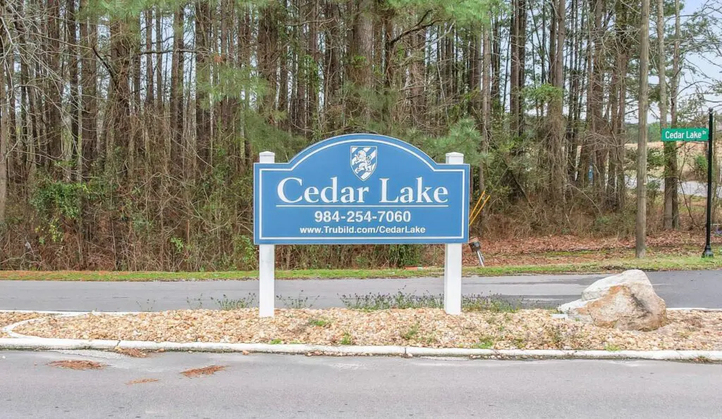 Blue Cedar Lake sign near trees